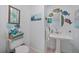 Charming powder room featuring a pedestal sink, whimsical fish decor, and nautical accents at 2590 N Beach Rd # 5, Englewood, FL 34223