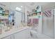 Bright bathroom featuring a white vanity, ample mirror, and walk-in shower with unique fish-themed decor at 2590 N Beach Rd # 5, Englewood, FL 34223