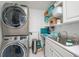 Functional laundry room featuring modern washer/dryer, sink, and ample storage at 2590 N Beach Rd # 5, Englewood, FL 34223