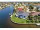An aerial view showcasing the property's waterfront location, private dock, and lush landscaping in a residential neighborhood at 261 Venezia Ct, Punta Gorda, FL 33950