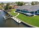 Aerial view of a property with a screened-in pool, a private dock, and beautifully landscaped grounds along the waterfront at 261 Venezia Ct, Punta Gorda, FL 33950