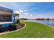 Expansive backyard featuring lush green lawn and waterfront views, complemented by well-manicured landscaping at 261 Venezia Ct, Punta Gorda, FL 33950