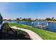 Backyard with lush landscaping, pavers leading to the dock, and a boat lift on the canal at 261 Venezia Ct, Punta Gorda, FL 33950
