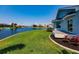 Landscaped backyard with modern deck overlooking the canal and lush greenery at 261 Venezia Ct, Punta Gorda, FL 33950