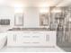 Bright bathroom featuring double sinks, marble counters, and a glass-enclosed shower at 261 Venezia Ct, Punta Gorda, FL 33950
