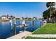 A private dock with a boat lift providing access to scenic waterways surrounded by well-maintained homes and palm trees at 261 Venezia Ct, Punta Gorda, FL 33950