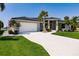 Charming single-story home with a white brick driveway, lush lawn, and a two-car garage at 261 Venezia Ct, Punta Gorda, FL 33950