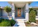 Close up of front entrance with orange door and manicured landscape at 261 Venezia Ct, Punta Gorda, FL 33950