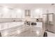 Modern kitchen features stainless appliances, white cabinetry, and island with marble countertop at 261 Venezia Ct, Punta Gorda, FL 33950