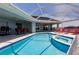 An outdoor pool with an outdoor kitchen and several lounge chairs at 261 Venezia Ct, Punta Gorda, FL 33950