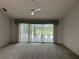 Spacious living room featuring a ceiling fan and sliding glass doors leading to the pool area at 3233 Meadow Run Dr, Venice, FL 34293