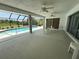 Spacious enclosed patio with ceiling fans, outdoor seating, and sliding glass doors opening to the pool area at 3233 Meadow Run Dr, Venice, FL 34293