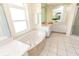 Bright, spacious bathroom with white tile flooring, a soaking tub, and lots of counter space at 3506 Saint Florent Ct, Punta Gorda, FL 33950