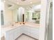 Bathroom showcasing dual vanity sinks, tiled floors, and large mirrors at 3506 Saint Florent Ct, Punta Gorda, FL 33950