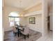 A dining area with wood-look flooring, complemented by a modern chandelier and large arched window at 3506 Saint Florent Ct, Punta Gorda, FL 33950