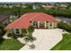 Stunning waterfront home featuring a red tile roof, a spacious driveway, and lush landscaping with palm trees at 3506 Saint Florent Ct, Punta Gorda, FL 33950