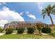 Exterior of home with a screened in patio and beautiful tropical landscaping at 3506 Saint Florent Ct, Punta Gorda, FL 33950