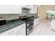 View of kitchen including stainless double oven and white cabinets, and breakfast nook overlooking the pool at 3506 Saint Florent Ct, Punta Gorda, FL 33950
