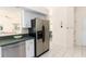 Kitchen features stainless steel appliances, white cabinetry, and tiled floors with a view to the living area at 3506 Saint Florent Ct, Punta Gorda, FL 33950