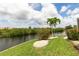 Landscaped backyard featuring a canal front view with a private dock at 3506 Saint Florent Ct, Punta Gorda, FL 33950