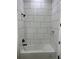 Clean bathroom featuring a tub, shower head and tiled walls at 3548 Mondovi Ct, Punta Gorda, FL 33950