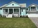 Beautiful light blue home with a covered front porch, white railings, and manicured lawn at 3548 Mondovi Ct, Punta Gorda, FL 33950