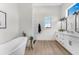 Modern bathroom featuring a freestanding tub, walk-in shower, and double vanity with sleek fixtures and bright lighting at 3548 Mondovi Ct, Punta Gorda, FL 33950