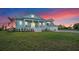 Charming two-story home with a well-manicured lawn and classic architectural details at sunset at 3548 Mondovi Ct, Punta Gorda, FL 33950