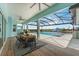 Relaxing covered patio with a dining set overlooking the inviting swimming pool and waterfront views at 3548 Mondovi Ct, Punta Gorda, FL 33950