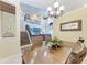 Bright dining room featuring a chandelier, hard wood floors, and view of the staircase and living room at 3800 Bal Harbor Blvd # 414, Punta Gorda, FL 33950