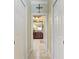 Hallway view into bath displaying wood vanity, mirror, stone tile floor and stone shower at 3800 Bal Harbor Blvd # 414, Punta Gorda, FL 33950