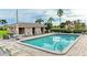 Community pool area with lounge chairs, tables, and a restroom under blue skies at 3800 Bal Harbor Blvd # 414, Punta Gorda, FL 33950