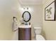 Charming powder room with decorative wallpaper, a dark wood vanity and a framed palm tree artwork at 3800 Bal Harbor Blvd # 414, Punta Gorda, FL 33950