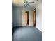Blue bedroom featuring carpeting, a ceiling fan, and an open doorway to a tiled bathroom at 4150 Enclave Pl, Punta Gorda, FL 33980