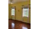 Bedroom with hardwood floors, yellow walls, a ceiling fan, and windows with tree views at 4150 Enclave Pl, Punta Gorda, FL 33980