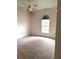 Bedroom featuring pink carpet, pink walls, and a pink ceiling fan with an arched window at 4150 Enclave Pl, Punta Gorda, FL 33980