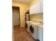 Laundry room featuring a washer, a dryer, white cabinets, and an electric water heater at 4150 Enclave Pl, Punta Gorda, FL 33980