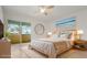 Staged bedroom features a balcony, ceiling fan, and beach-themed art at 4346 Rayfield Dr # 4346, Sarasota, FL 34243