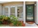 Close-up view of the townhome entrance featuring a storm door and mature landscaping at 4346 Rayfield Dr # 4346, Sarasota, FL 34243