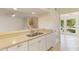 Bright kitchen features a stainless steel sink, cream cabinets and updated countertops at 4346 Rayfield Dr # 4346, Sarasota, FL 34243
