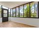 Bright sunroom with floor to ceiling windows overlooking tropical landscape at 4346 Rayfield Dr # 4346, Sarasota, FL 34243