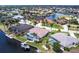 Aerial view of a waterfront home with screened pool, lush landscaping, boat dock, and serene canal access at 523 Saint Girons Ct, Punta Gorda, FL 33950