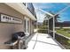 Back porch with a grill, 'Free Moorings' sign, screened-in lanai, and views of the backyard and surrounding landscape at 523 Saint Girons Ct, Punta Gorda, FL 33950