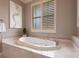 Close-up of a soaking tub in a well-lit bathroom with neutral tones and tiled surround at 523 Saint Girons Ct, Punta Gorda, FL 33950