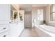 Bright bathroom featuring a soaking tub, white cabinetry, and decorative art at 523 Saint Girons Ct, Punta Gorda, FL 33950