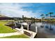 Waterfront property with a private boat dock featuring a boat lift and stunning views of the canal and surrounding homes at 523 Saint Girons Ct, Punta Gorda, FL 33950