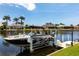 Boat on a lift at a private dock on a canal surrounded by tropical landscaping at 523 Saint Girons Ct, Punta Gorda, FL 33950