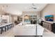 Bright, open-concept living room with a comfortable white sectional, tile flooring, and sliding glass doors to the pool at 523 Saint Girons Ct, Punta Gorda, FL 33950