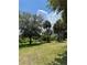 Backyard with lush green grass and beautiful trees, offering a private outdoor space at 5727 Beechwood St, Punta Gorda, FL 33982