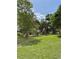 Expansive backyard with lush lawn, mature trees, and seating area perfect for outdoor activities and relaxation at 5727 Beechwood St, Punta Gorda, FL 33982
